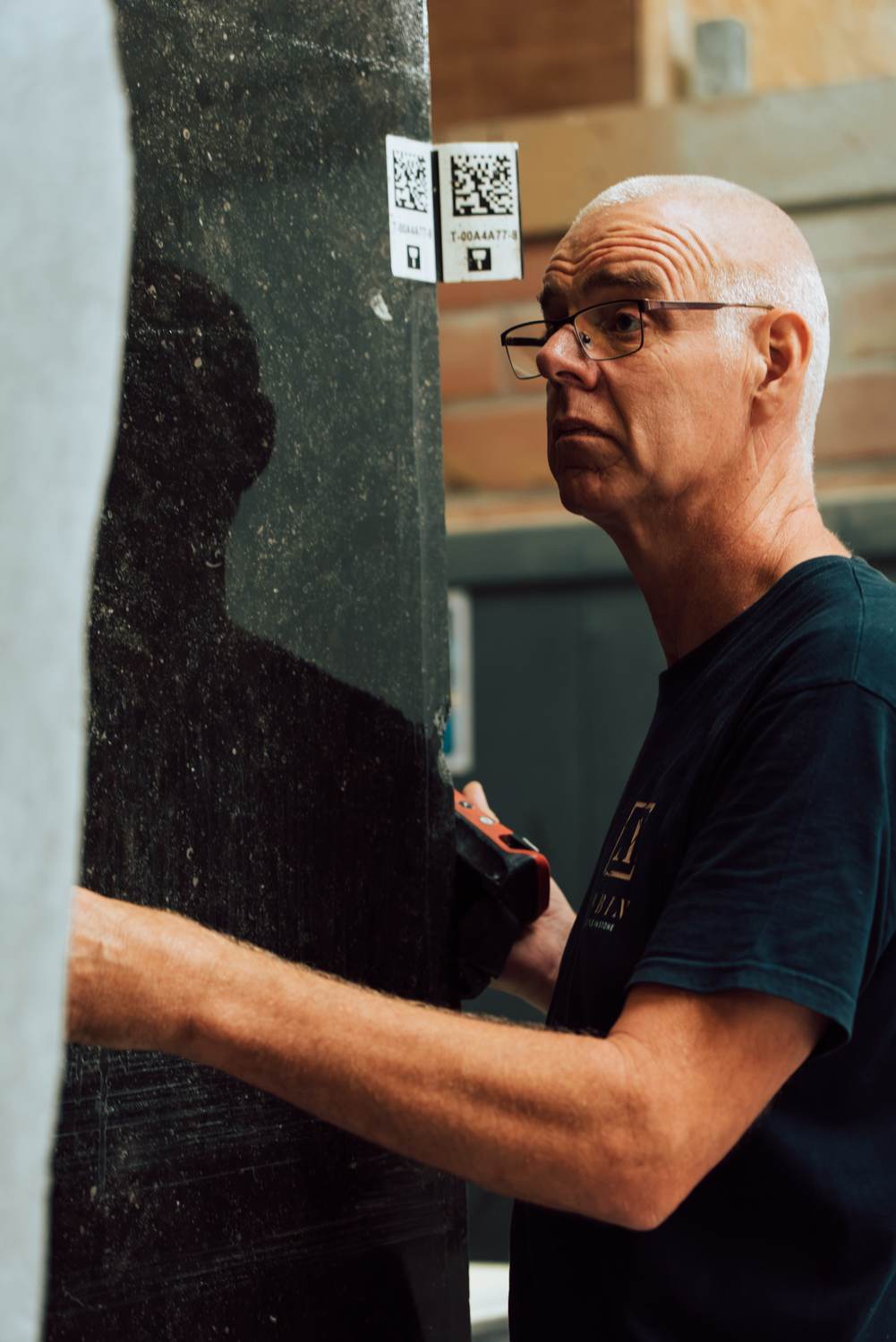 Zager naast een zwarte plaat met QR-code